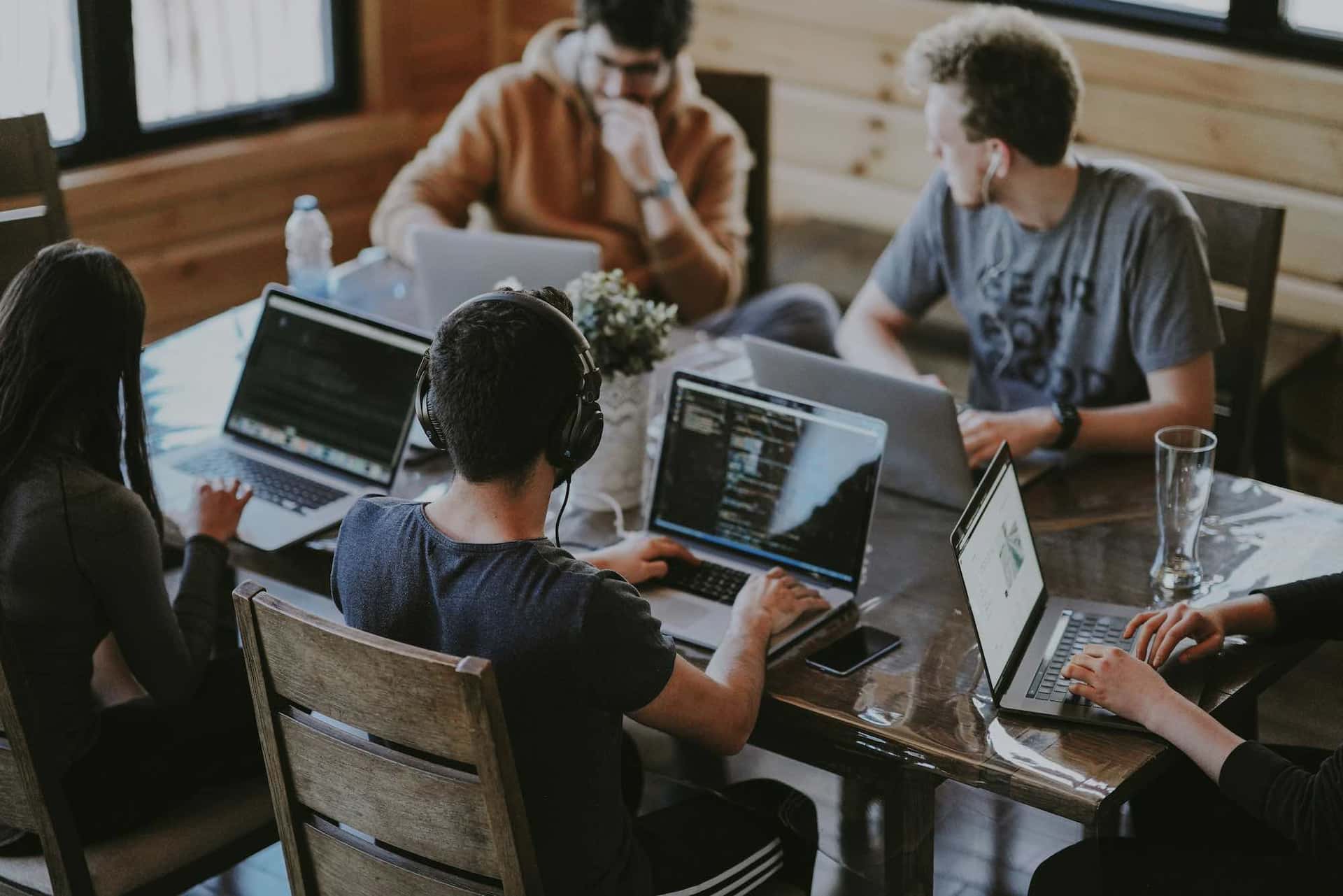 Colleagues working together at laptops around a shared table