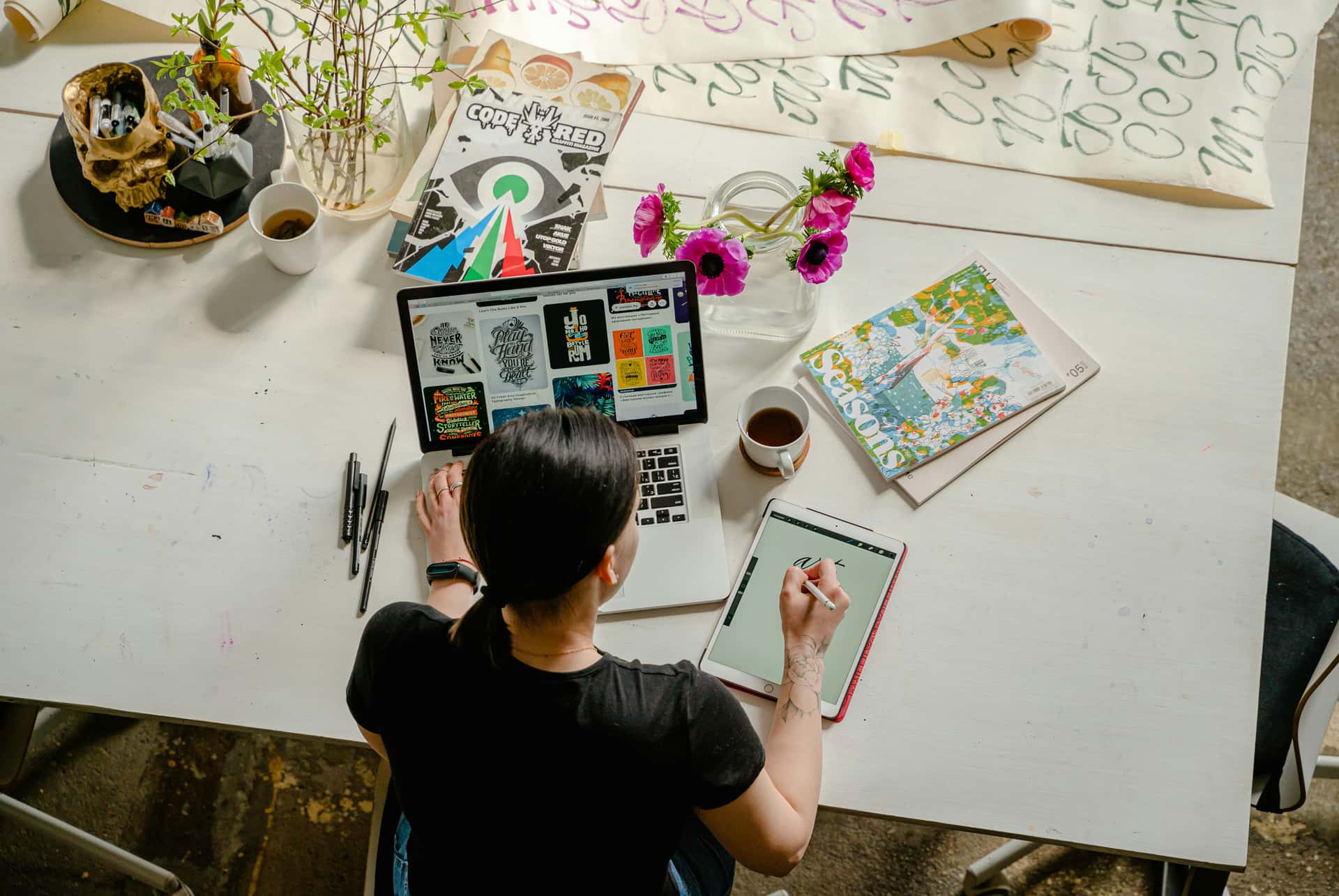 A desk laid out with deal notes, a tablet and a coffee mid-review