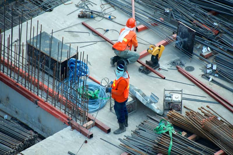 Construction crew working on a site with steel reinforcement laid out
