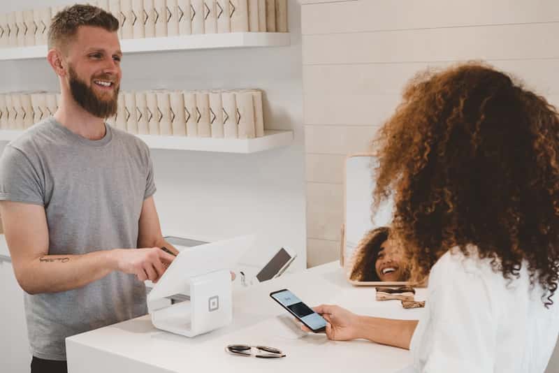 Owner serving a customer at the counter of a small venue