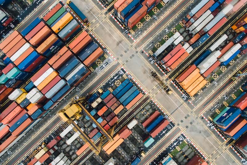Freight containers stacked in rows at a logistics yard, seen from above