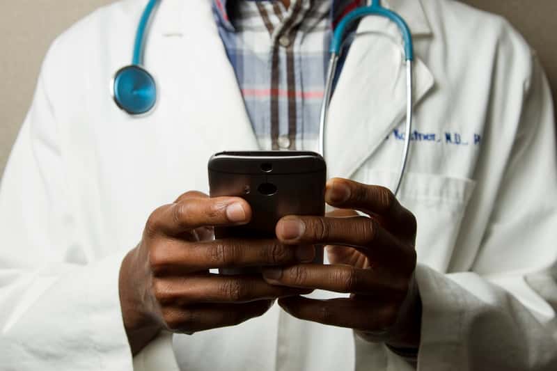 Health practitioner checking practice details on a phone