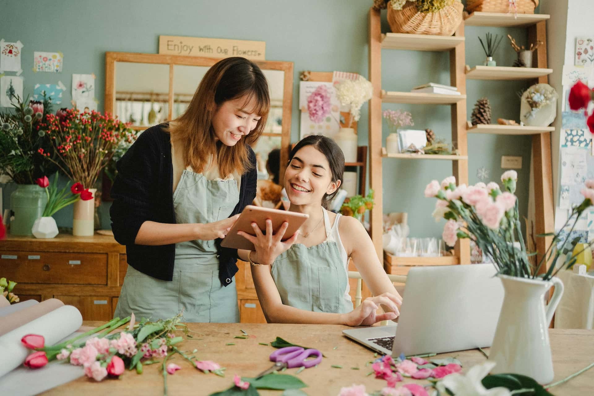 Two business owners talking over a tablet in their shop
