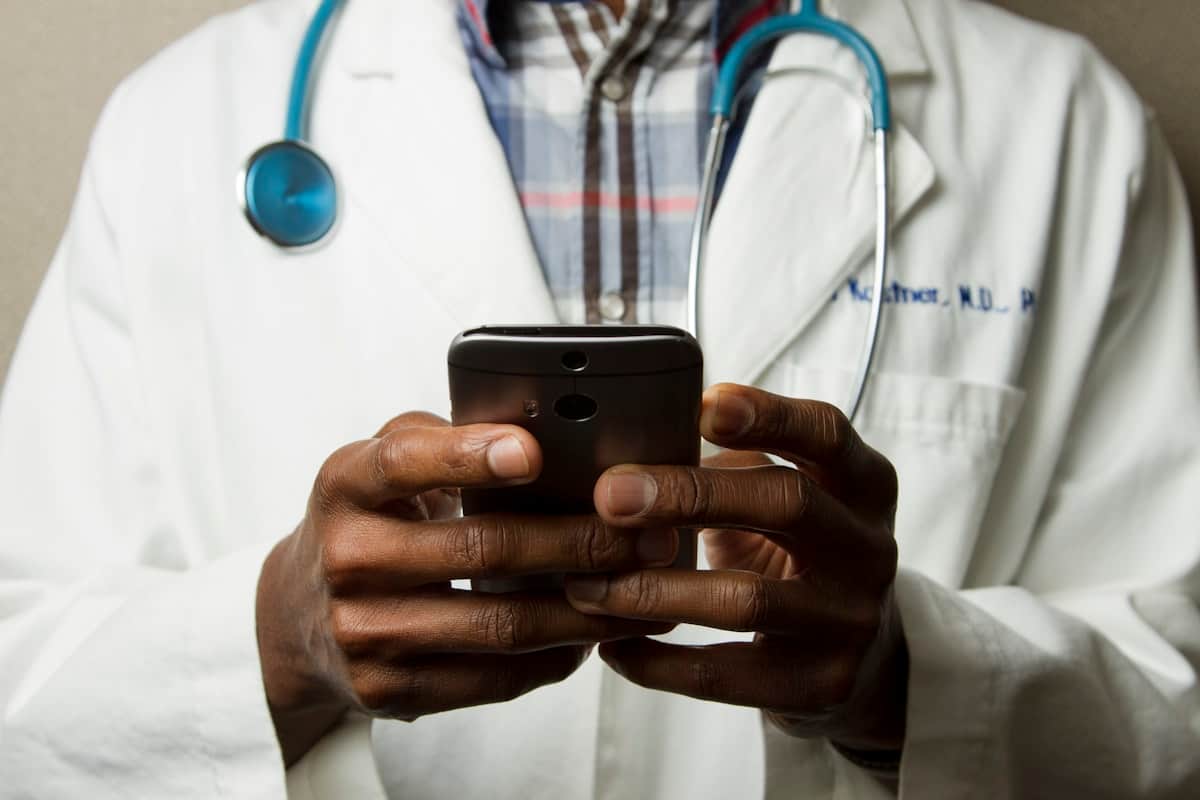 Health practitioner checking practice details on a phone