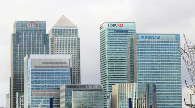 Business owner comparing loan options on laptop with financial documents