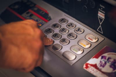 Business owner comparing loan costs on a calculator and laptop screen
